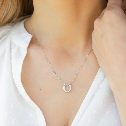 Silver horseshoe necklace with U-shaped pendant and small clear stones