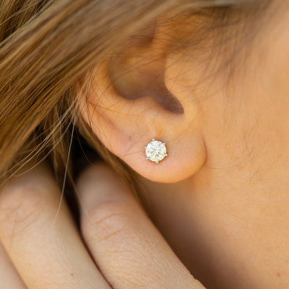 Round lab-grown diamond stud earring in four-prong setting, white metal, on ear