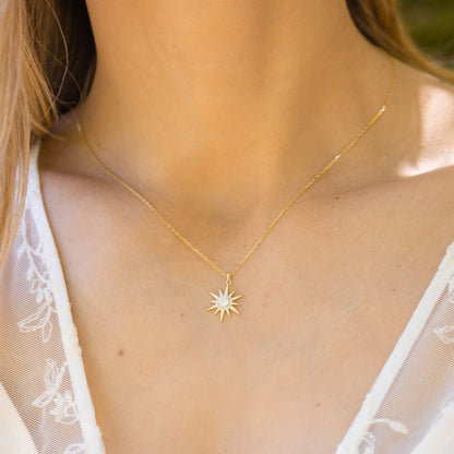 Gold starburst pendant necklace with small crystal sunburst charm on chain