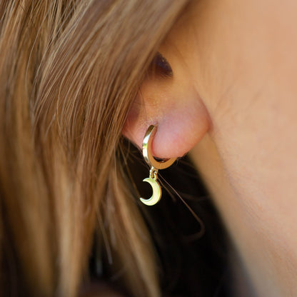 Gold-tone hoop earring with small crescent moon charm dangle