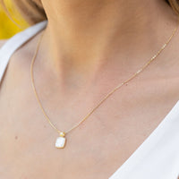 Gold pendant necklace with square mother-of-pearl charm and ribbed bail