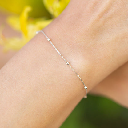 Silver satellite chain bracelet with small round beads along wrist