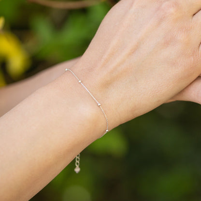 Silver satellite chain bracelet with round beads on wrist