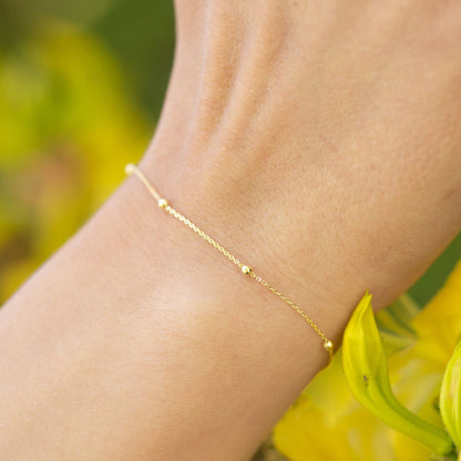 Gold satellite chain bracelet with small round beads on wrist